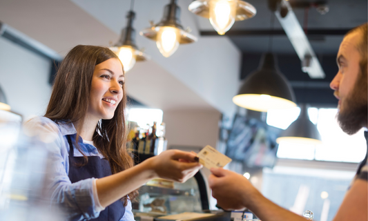 Woman giving a customer back their credit card