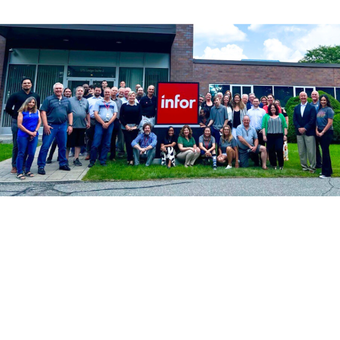 Group of Infor employees posing in front of a building with an Infor logo.