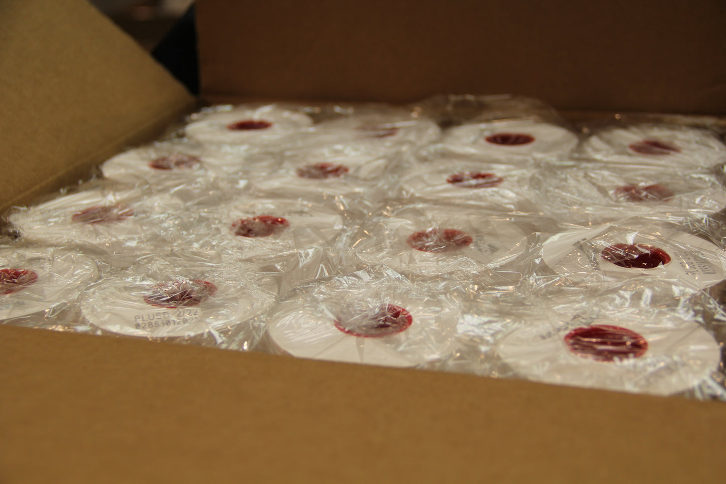 Bulk case of full coverage sticky label paper rolls wrapped in plastic for POS printing